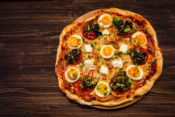 Pizza pepperoni with hard boiled eggs on wooden table
