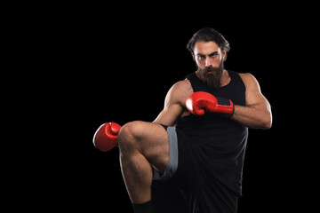 Fototapeta na wymiar Kickboxer man fighting against black background. Sport concept.