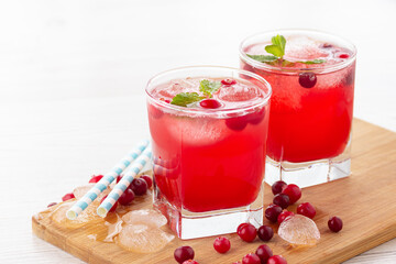 Red coctail with cranberry, vodka and ice. Refreshment drink.
