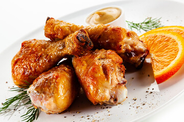 Barbecue chicken drumsticks with vegetables on white background
