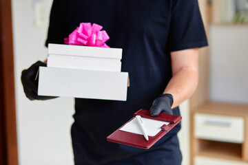 Courier man contactless delivery presents, gift box during a coronavirus epidemic.