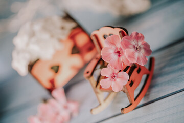 dollhouse wooden furniture and flowers. children's wooden furniture and garden flowers. wooden toys surrounded by delicate flowers