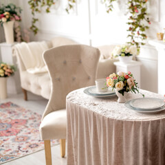 Living room decorated in classic style with  antique chairs and served coffee table decorated with floral arrangement
