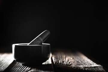 Stone mortar with pestle on black background