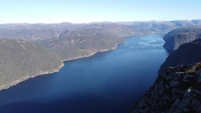 Aerial drone push in of Fjord surrounded by mountain view of Rogaland Norway at golden hour