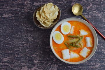 Lontong Sayur, Indonesian cuisine. Compressed rice cake or lontong with vegetables (chayote and yard long beans) cooked in coconut milk and spices. Served with boiled egg and emping cracker