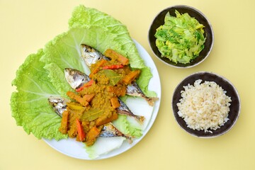 Pesmol Ikan Makarel (Indonesian food) or Mackerel fish with chili turmeric coconut milk sauce served with rice and sauteed napa cabbage