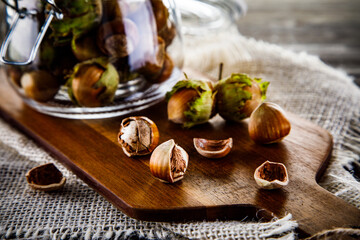 Ripe hazelnuts in shells on wooden table
