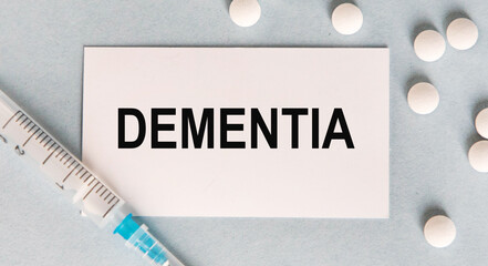 on the card text DEMENTIA, next to the syringe and tablets.