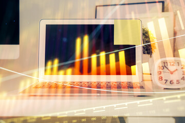 Stock market graph on background with desk and personal computer. Multi exposure. Concept of financial analysis.