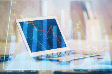 Stock market graph on background with desk and personal computer. Multi exposure. Concept of financial analysis.