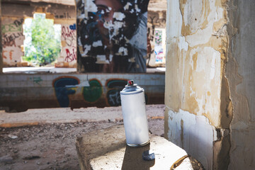 graffiti spray can picked up then put back. spray can standing in graffiti building.