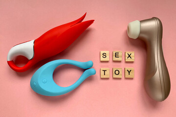 Adult toys. Three vibratos on a pink background. Inscription SEX TOY. Useful for sex shop
