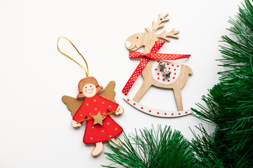 A wooden reindeer and little angel lying on a white background. Christmas decorations.