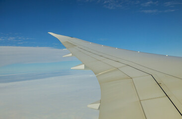 Obraz premium Clouds and sky as seen on a wing of an airplane flying