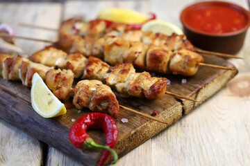 Selective focus. Appetizing chicken skewers on wooden sticks. Rustic style.