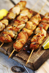 Selective focus. Appetizing chicken skewers on wooden sticks. Rustic style.