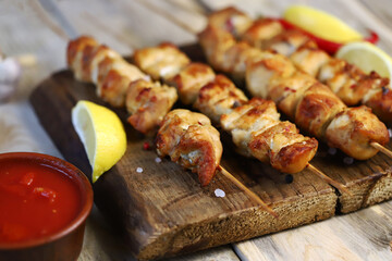 Selective focus. Appetizing chicken skewers on wooden sticks. Rustic style.