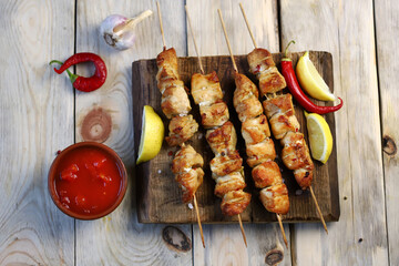 Selective focus. Appetizing chicken skewers on wooden sticks. Rustic style.