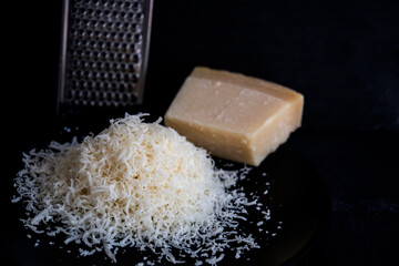 hand-grated Parmesan cheese on a black plate