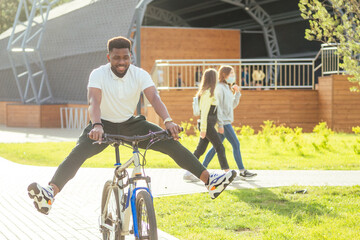 Obraz premium ecology and transportation concept. modern young Afro American businessman cycling to work on bicycle