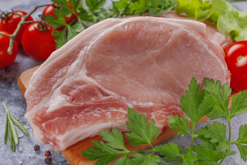 Raw pork steak with tomatoes and herbs.