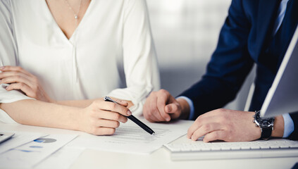 Unknown businessman and woman discussing contract in office. closeup.Business people or lawyers working together at meeting. Teamwork and partnership