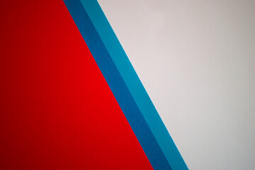 Diagonally divided red, blue and white colored paper background wallpaper
