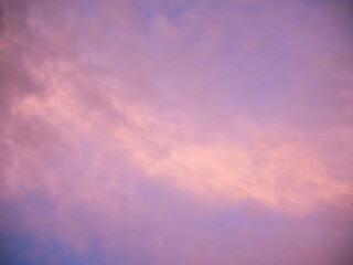 Multicolored clouds during sunset. Clouds, purple, hazy, blue and violet sky, hints of yellow