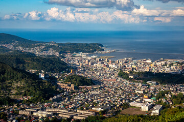 Fototapeta na wymiar 天狗山山頂から見える、小樽の市街地とその奥にある石狩湾、雲の浮かぶ青空