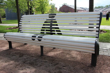 Park bench with an advertisement for social distance. 