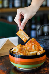 nachos chips and beer snack in the colorful bowl on the table