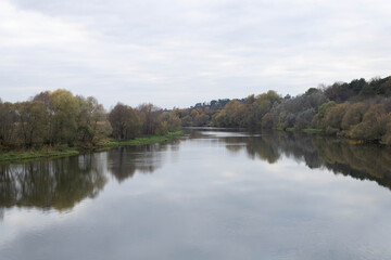 Fototapeta na wymiar Late autumn. River in the Park on an autumn day, the water looks brownish-yellow,