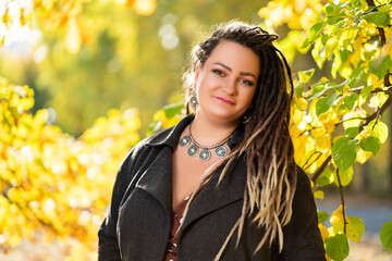 Young happy woman with dreadlocks outdoors in autumn