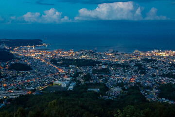 Fototapeta na wymiar 天狗山の展望台から見た、北海道三大夜景と呼ばれる小樽市街の夜景、夕焼けから夜に変わる空と石狩湾