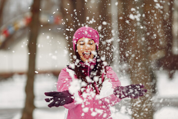 Fototapeta na wymiar Woman in a winter park. Lady in pink sportsuit.
