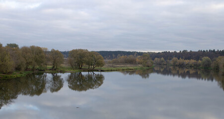 Obraz premium Late autumn. River in the Park on an autumn day, the water looks brownish-yellow,
