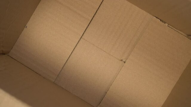 Delivery Cardboard Box From The Inside Close-up. Empty Open Pack. Brown Folds. View From Above. Slow Rotation