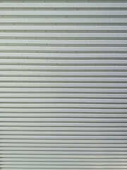 Metallic roll up door. Old Steel rolling shutter background. Metal security shutters. Abstract wire frame background. Galvanized steel wall plate