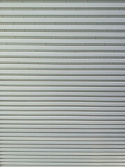 Obraz premium Metallic roll up door. Old Steel rolling shutter background. Metal security shutters. Abstract wire frame background. Galvanized steel wall plate