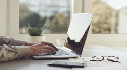 Male hands typing on computer keyboard closeup, business man or student using laptop at home,...