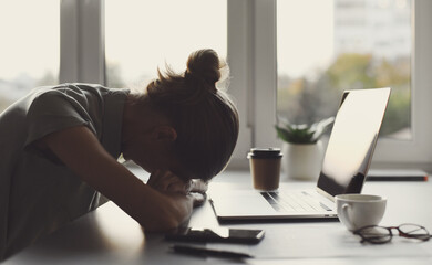 Tired and overworked business woman. Young exhausted girl sleeping on table during her work using...