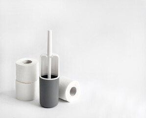 White and gray plastic toilet brush and toilet paper on white background
