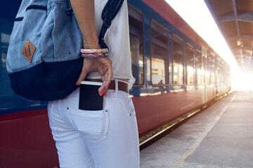 Woman using cellphone on a train station.