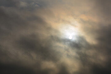 Obraz premium The white disc of the sun in a cloudy sky.