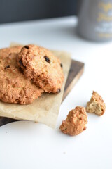 Gray jar with homemade oatmeat cookies on wooden board. Copy space.