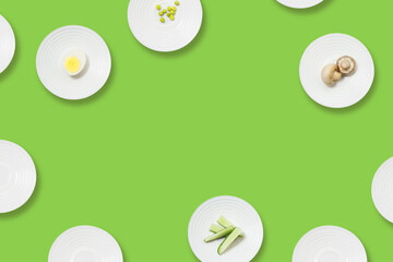 Healthy food minimalist flat lay. White plates with diet food on a green background with copy space. Diet for weight loss.