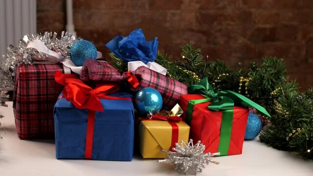 Christmas greeting card. Christmas gift boxes in a stack of presents. New year presents, festive and holiday shopping. Colorful holidays gift boxes and decoration on table. Home New Year's Eve comfort