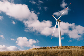 wind turbine with clouds and sky. Wind power station with a group of wind turbines onshore in a...