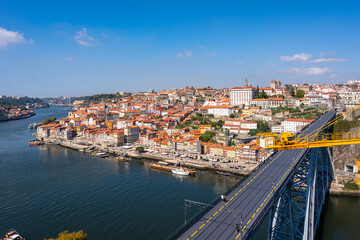 Panoramic top view of the Bridge of Luis 1. the banks of the Douro river in the city of Porto. Hill descending to the water with colorful houses. Lots of cafes on the waterfront and traditional boats.